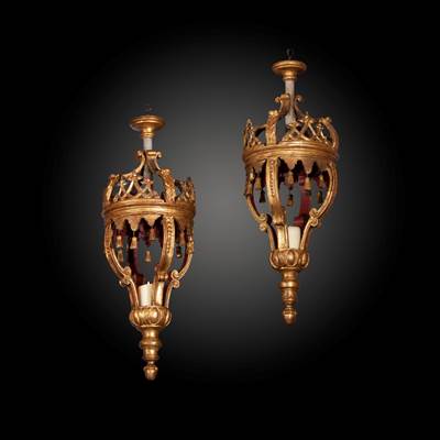 Paire de lanternes en bois doré et finement sculpté à décor de lambrequins terminant par des pompons et de couronne ajourée au sommet, XVIIIème (hauteur 80 cm, diamètre 30 cm)