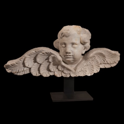 Tête d'ange aux ailes déployées en marbre blanc de Carrare, Italie, XVIIIème (hauteur 29 cm, largeur 65 cm, profondeur 15 cm) reposant sur un socle en métal (hauteur totale 41 cm)
