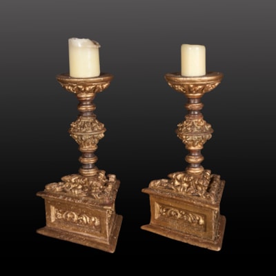 Paire de chandeliers en bois finement sculpté et doré, fût balustre à décor feuillagé reposant sur une base triangulaire, Italie, début XVIIème (hauteur 44 cm, base : 26 cm x 26 cm x 26 cm)