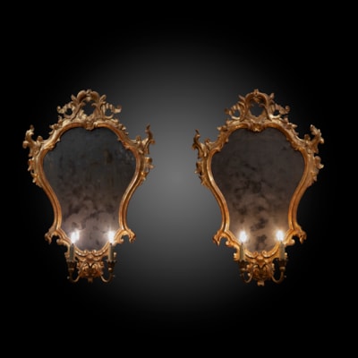 Paire de miroirs en bois finement sculpté et doré, glaces d'origine, 2 bras de lumière, Venise, XVIIIème (hauteur 84 cm, largeur 57 cm)